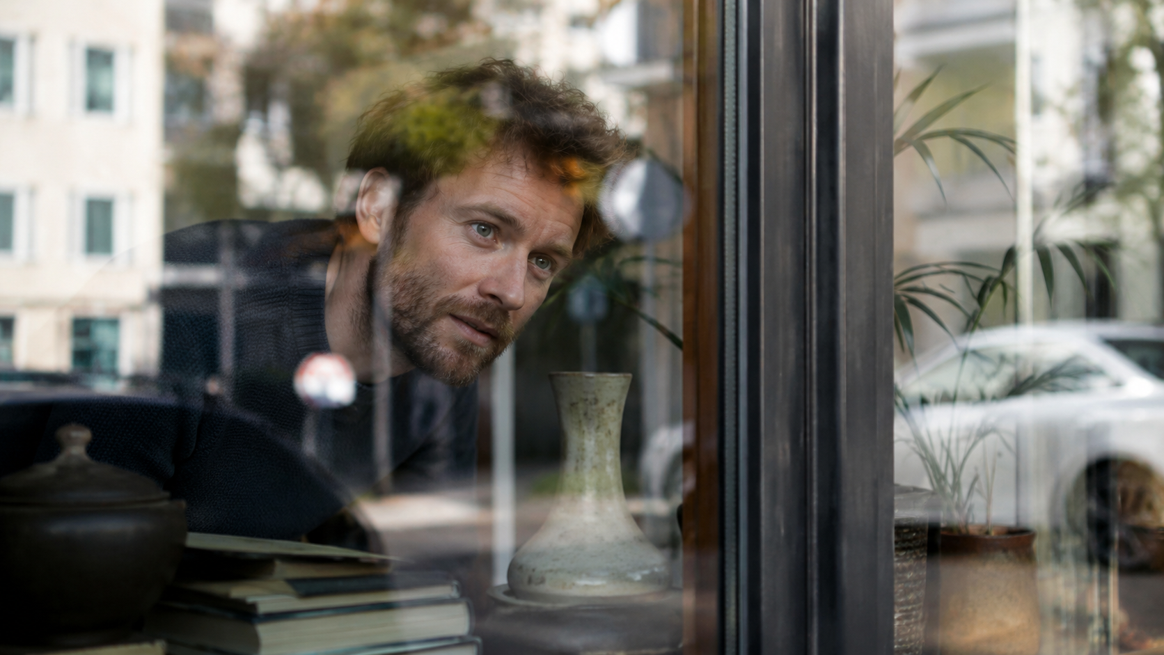 Ein Fenster mit sanftem Spiegelbild und einem Frühstückstisch davor.